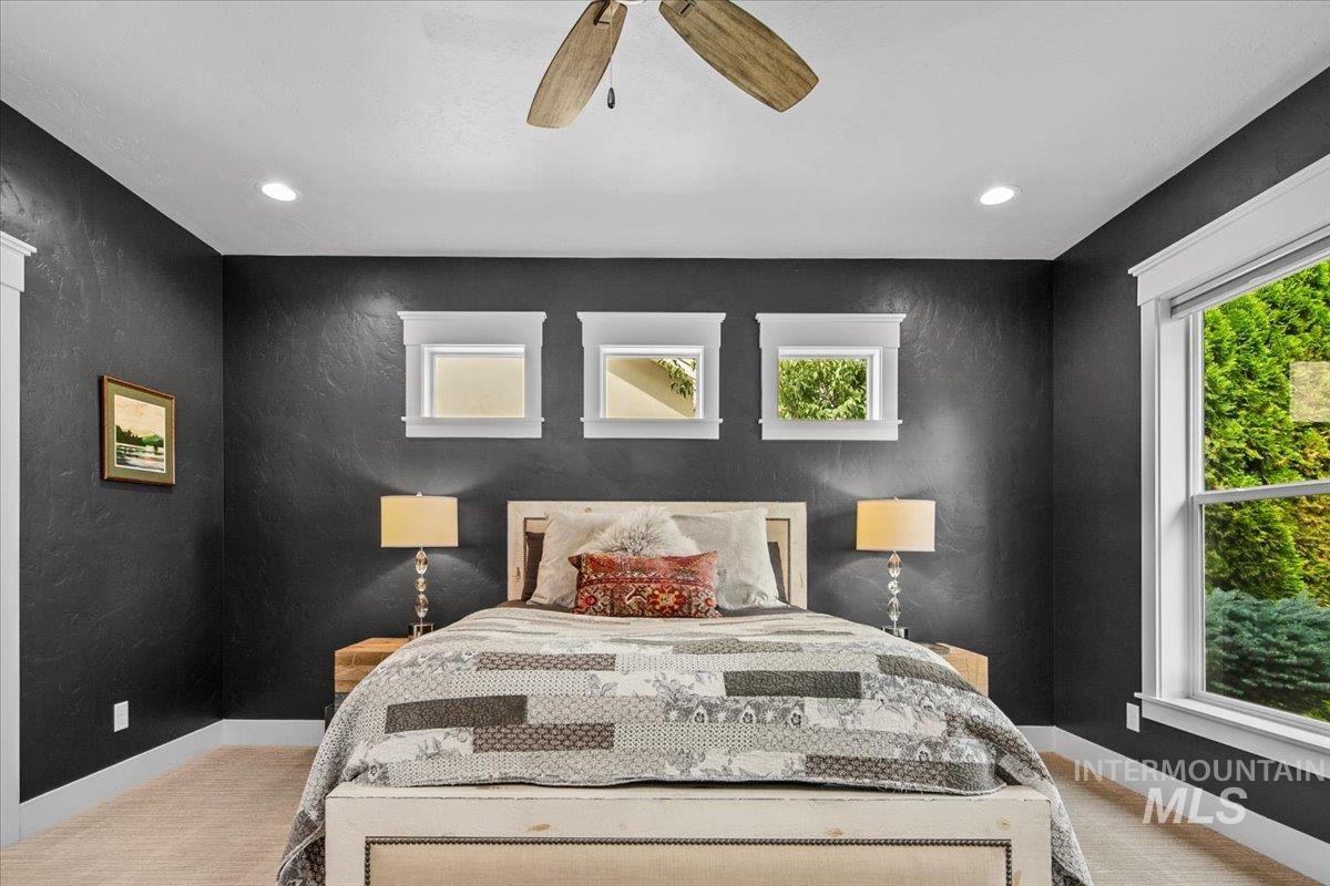 Bedroom with light colored carpet, ceiling fan, a textured wall, and recessed lighting