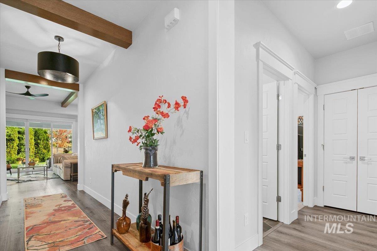 Hall featuring wood finished floors and beam ceiling