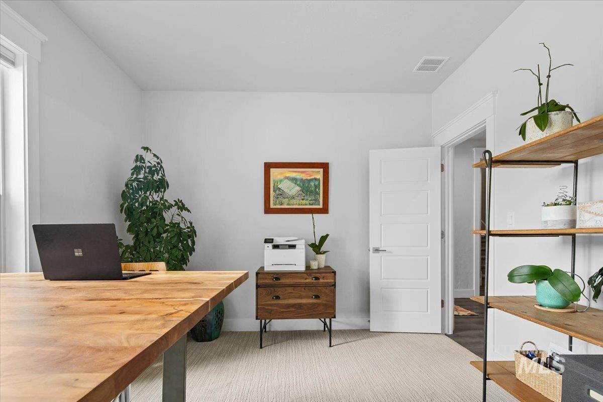 Office space with light colored carpet and baseboards