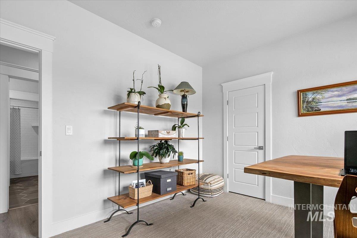 Office with baseboards and light carpet