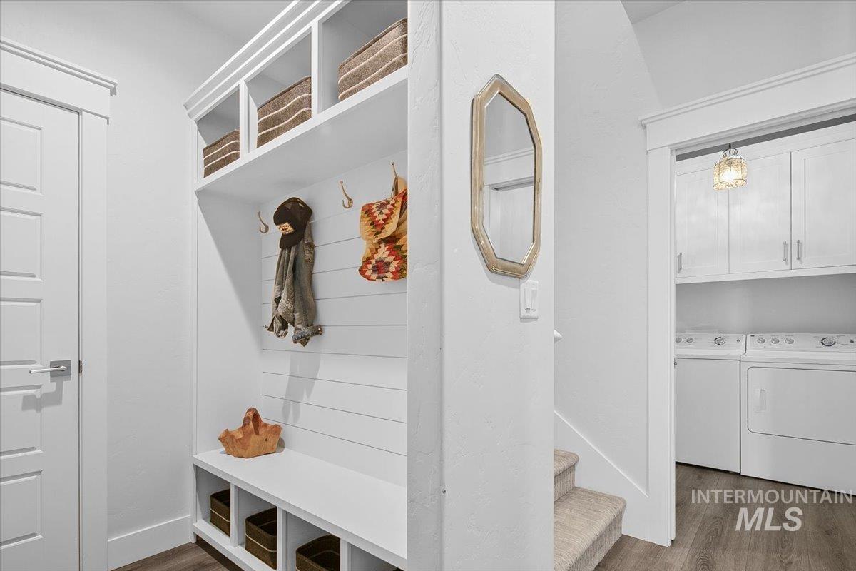 Mudroom with dark wood finished floors and washer and dryer