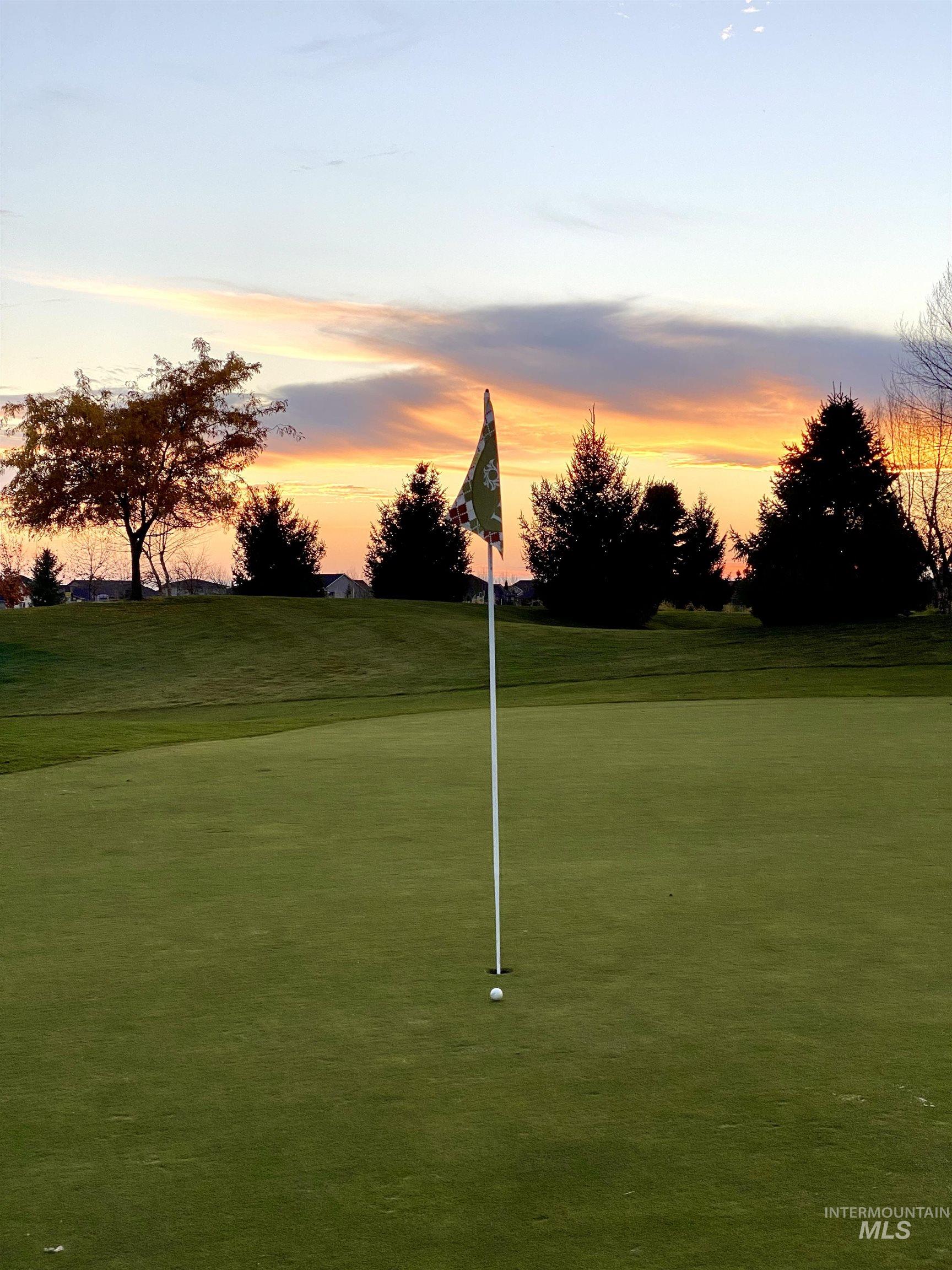 View of community featuring a yard, view of golf course, and a putting green