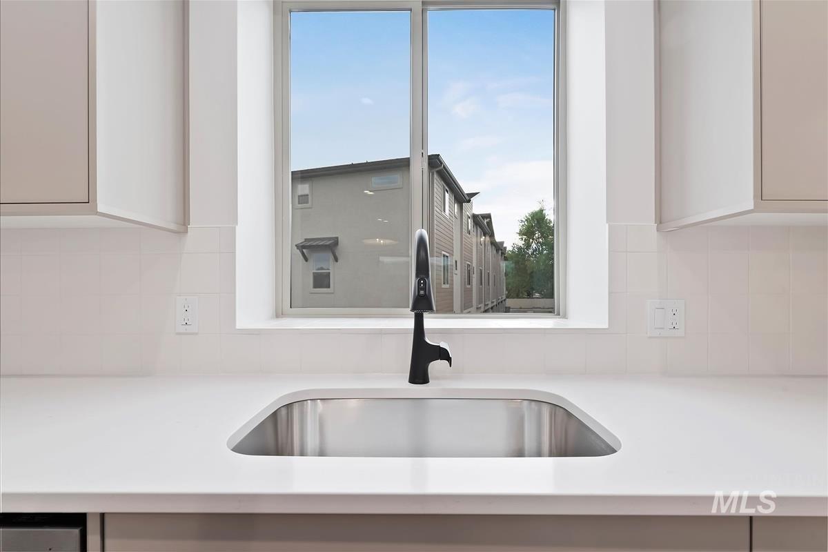 Kitchen with light stone counters and tasteful backsplash