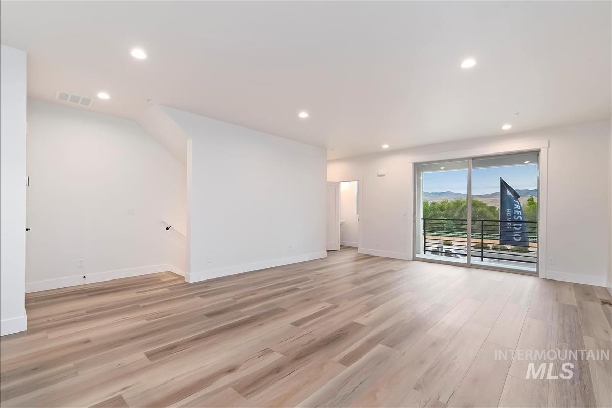 Unfurnished living room featuring recessed lighting, light wood-type flooring, and a mountain view