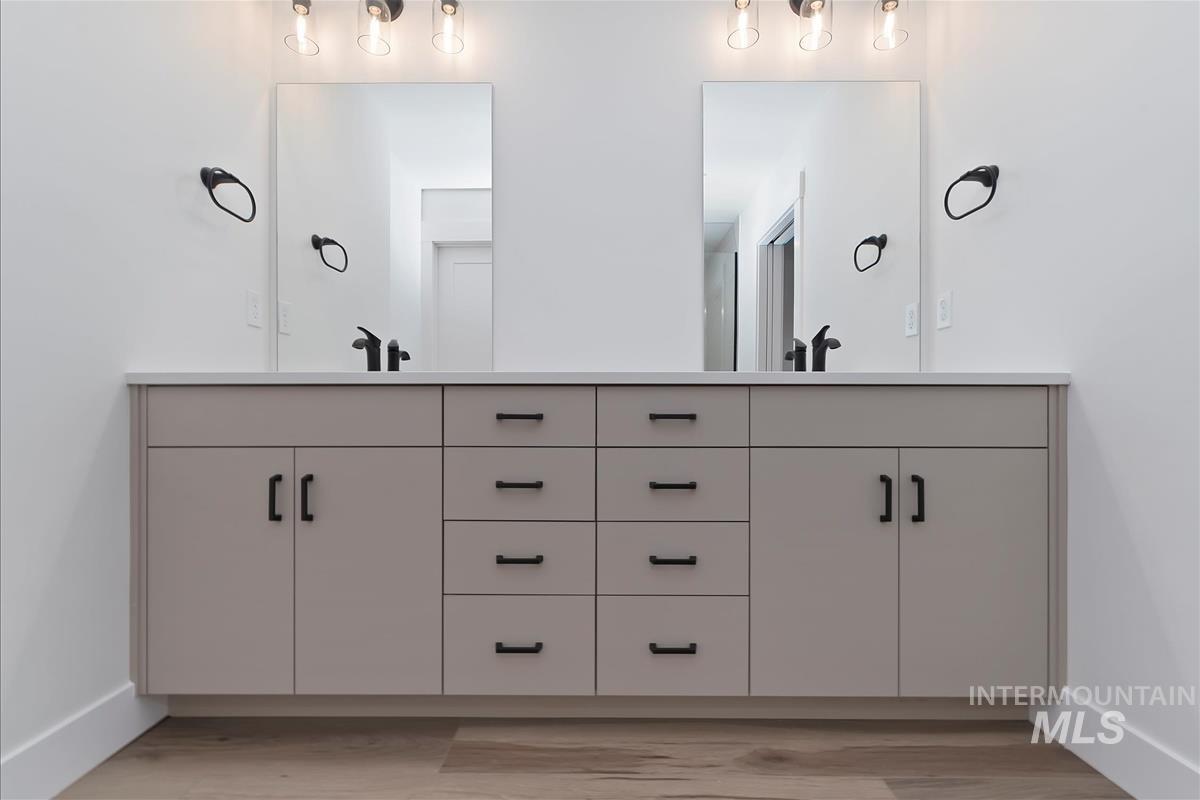 Full bathroom with double vanity and light wood finished floors
