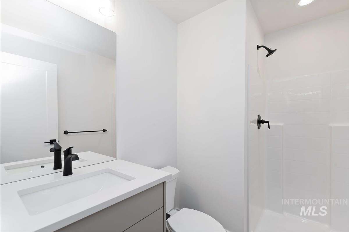 Bathroom with vanity, a stall shower, and recessed lighting