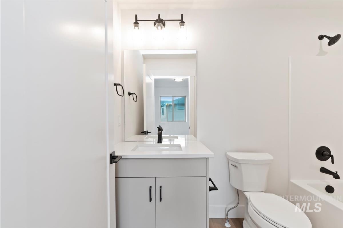 Bathroom with vanity, shower / washtub combination, and light wood finished floors