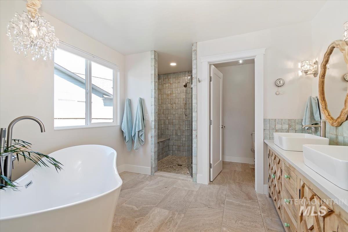 Bathroom with a shower stall, a freestanding bath, and double vanity