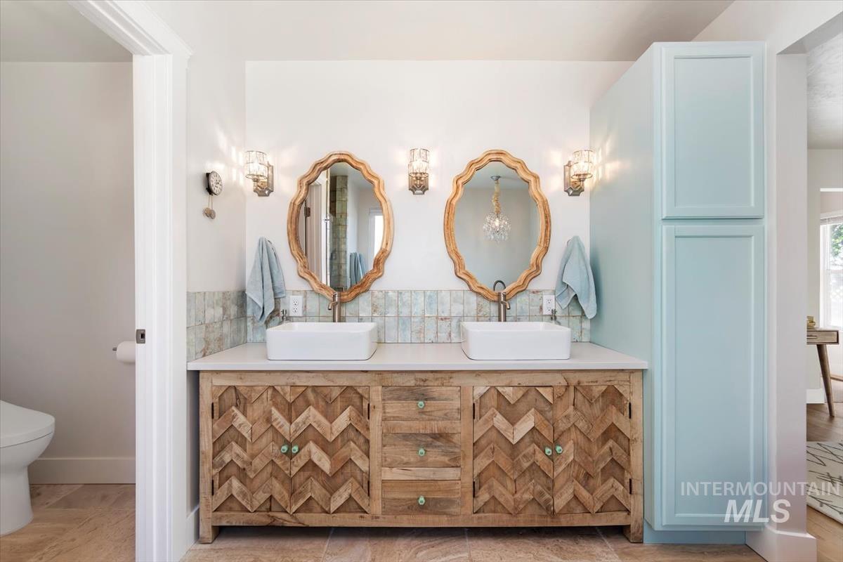 Full bathroom featuring double vanity and toilet