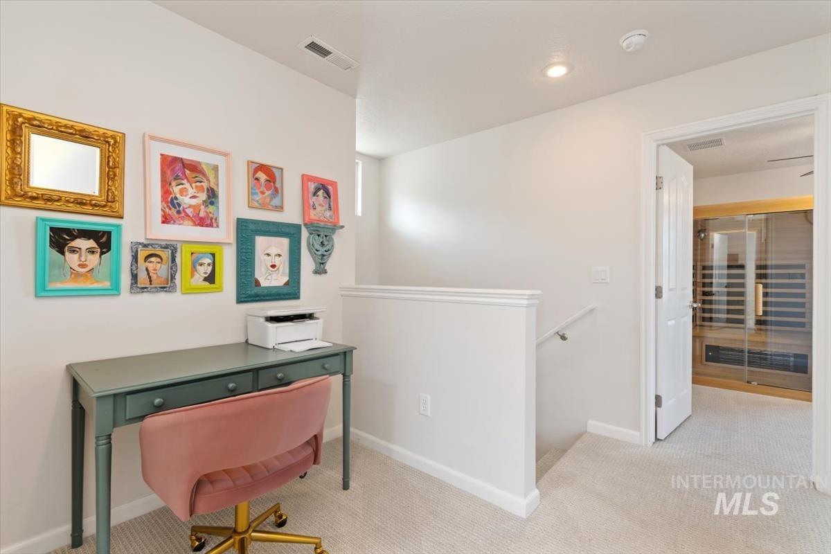 Carpeted home office featuring baseboards