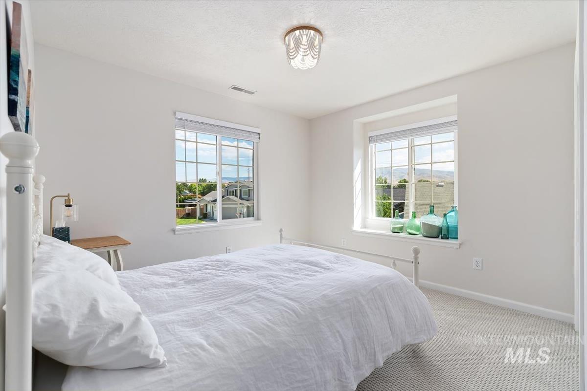 Bedroom featuring multiple windows, carpet flooring, and a textured ceiling