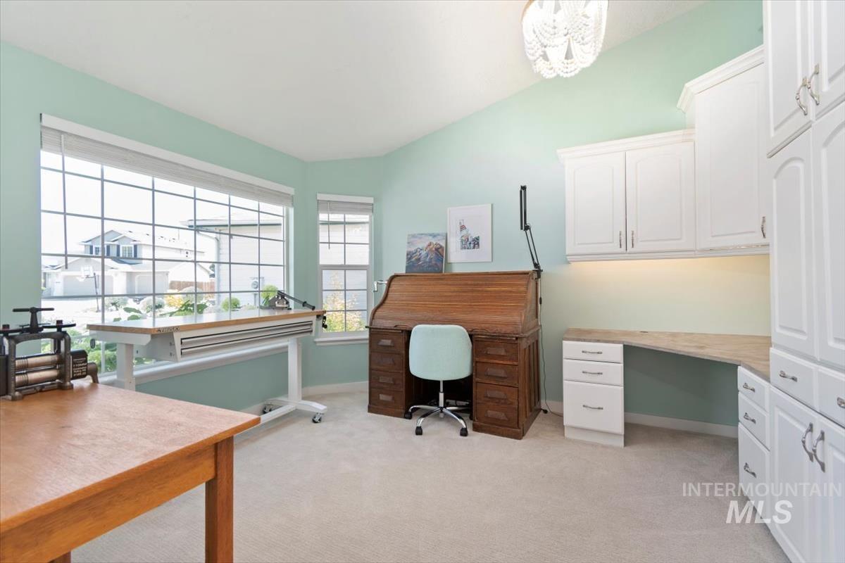 Office with light carpet, lofted ceiling, and a chandelier