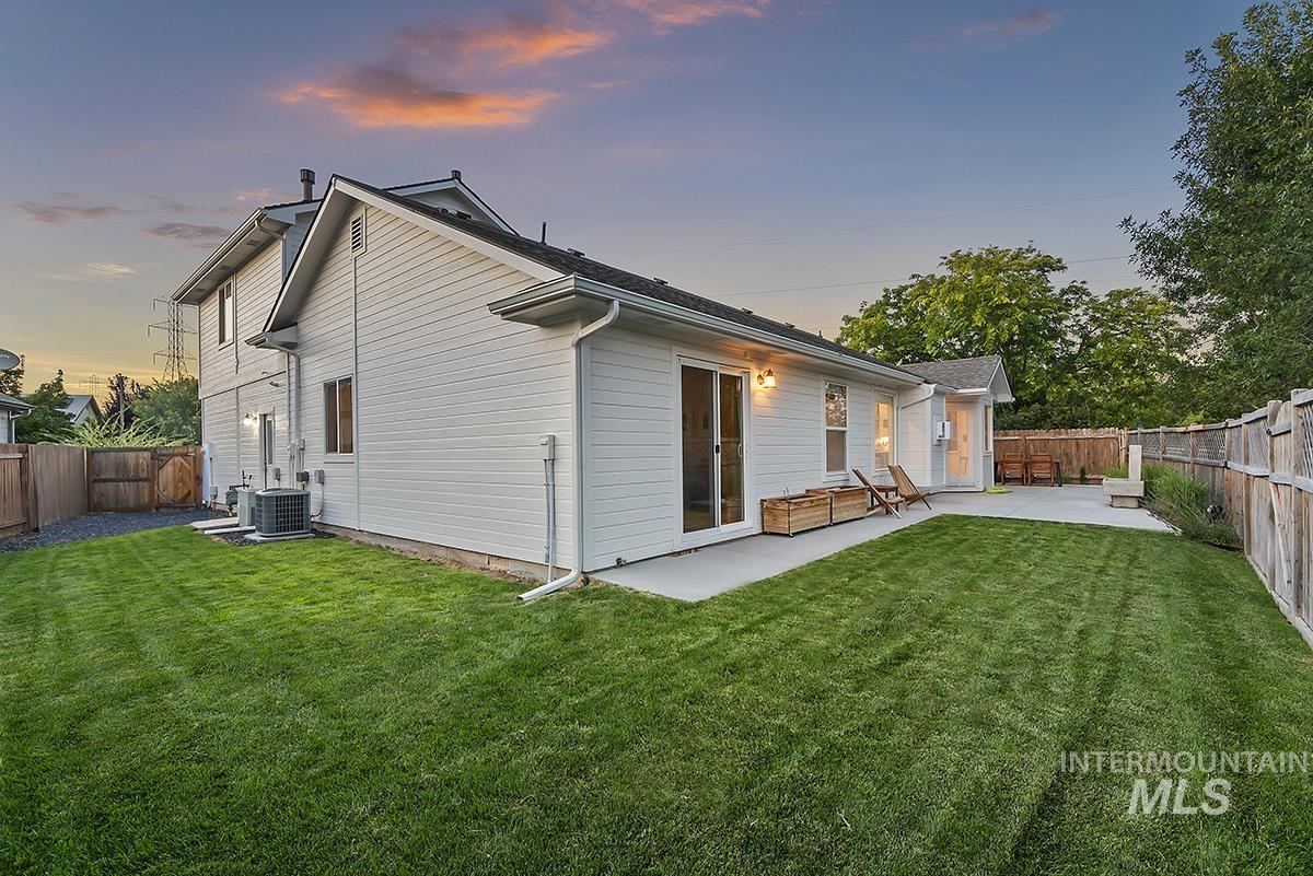 Back of house at dusk with a patio area and a fenced backyard