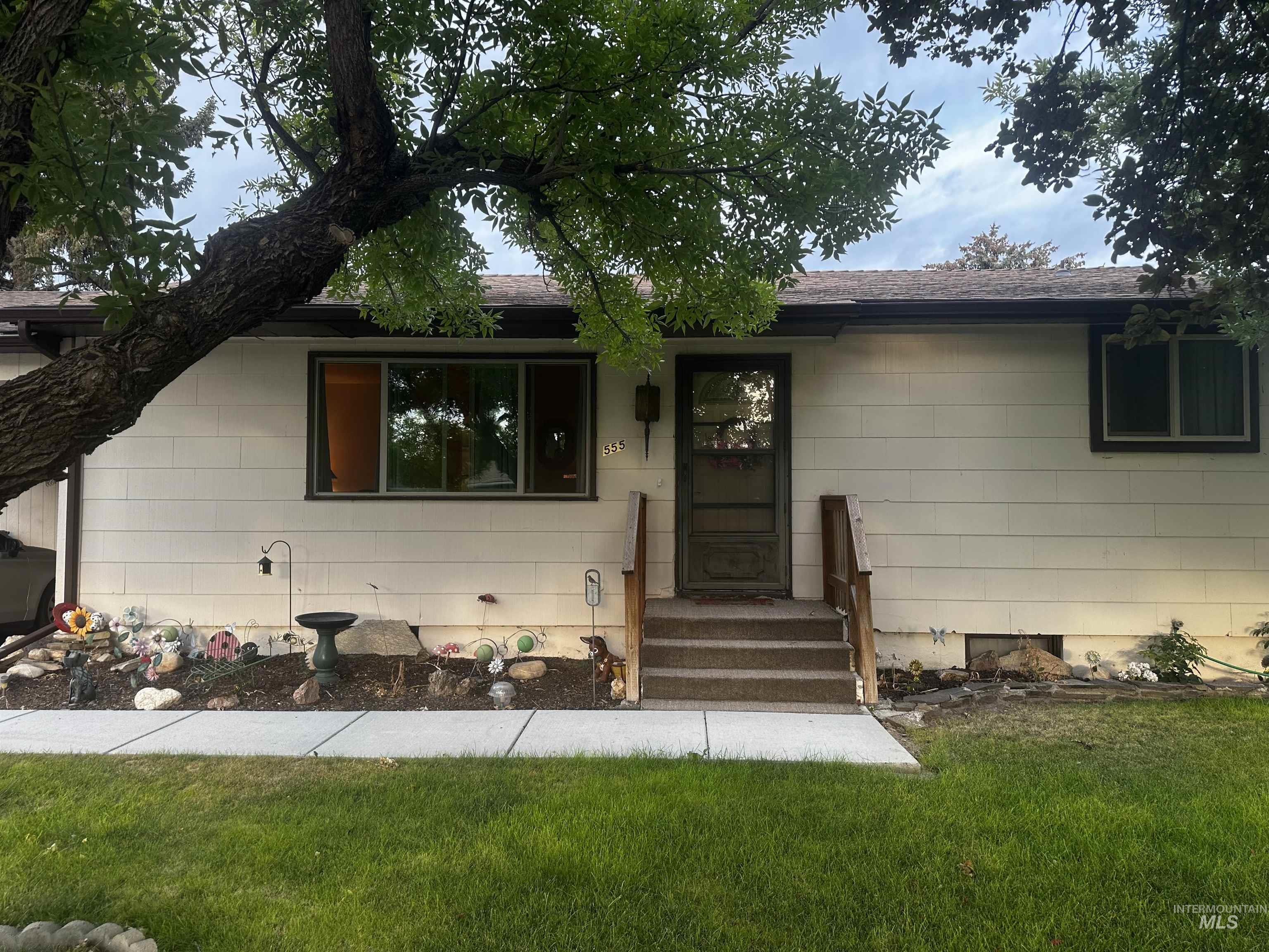 View of front of house with a front yard and a shingled roof