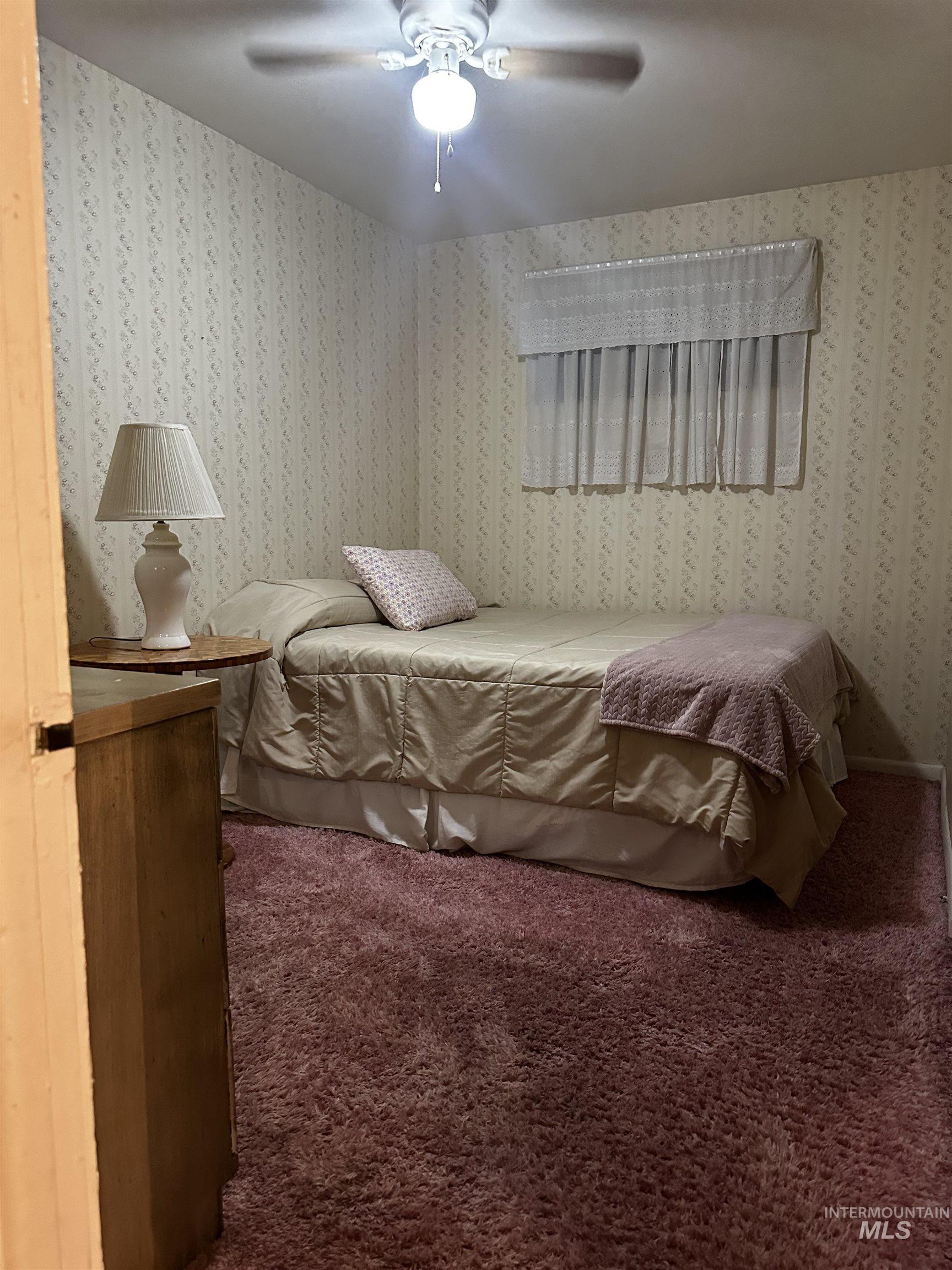 Carpeted bedroom featuring a ceiling fan