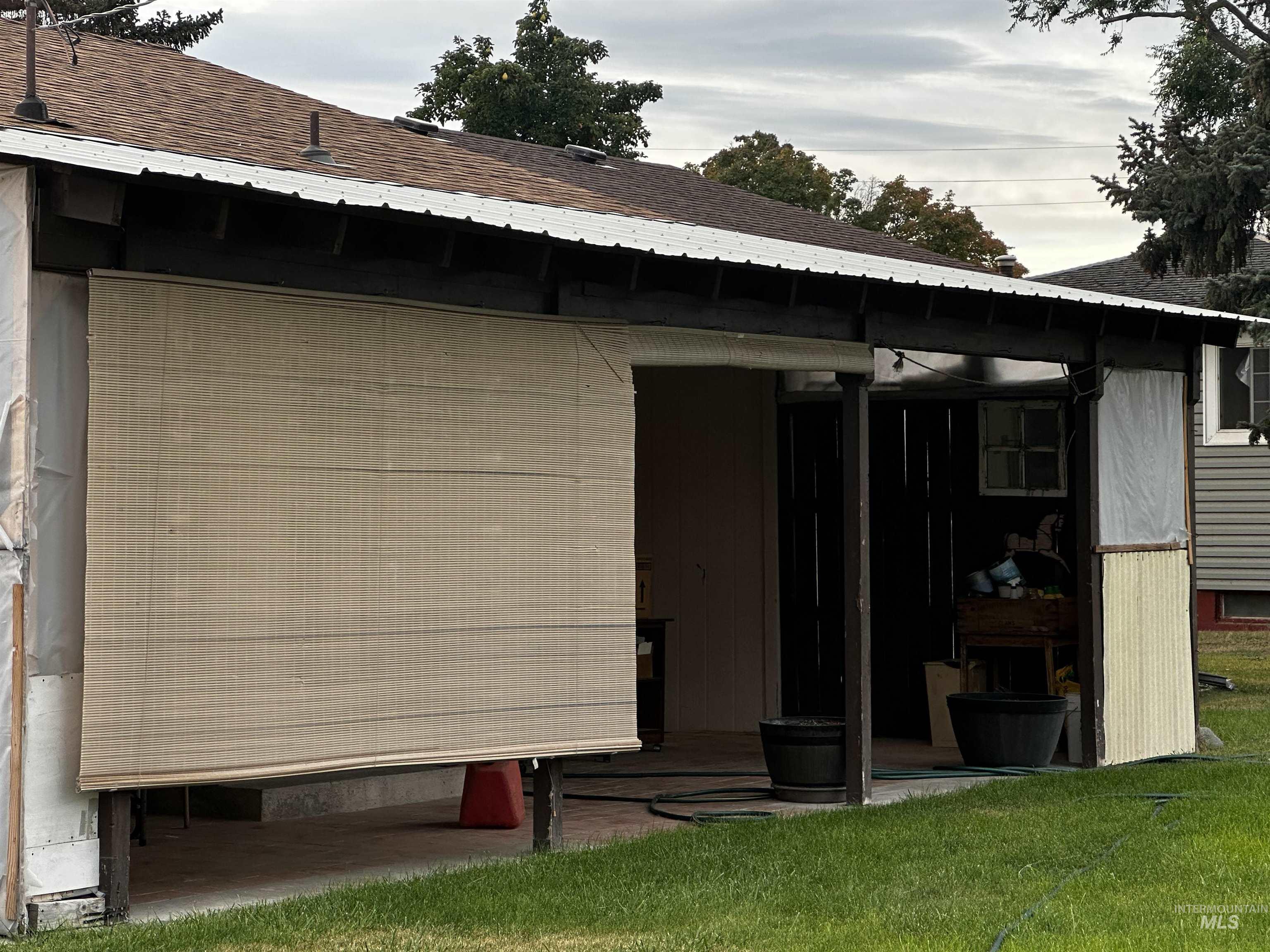 Rear view of property featuring a patio, a yard, and roof with shingles