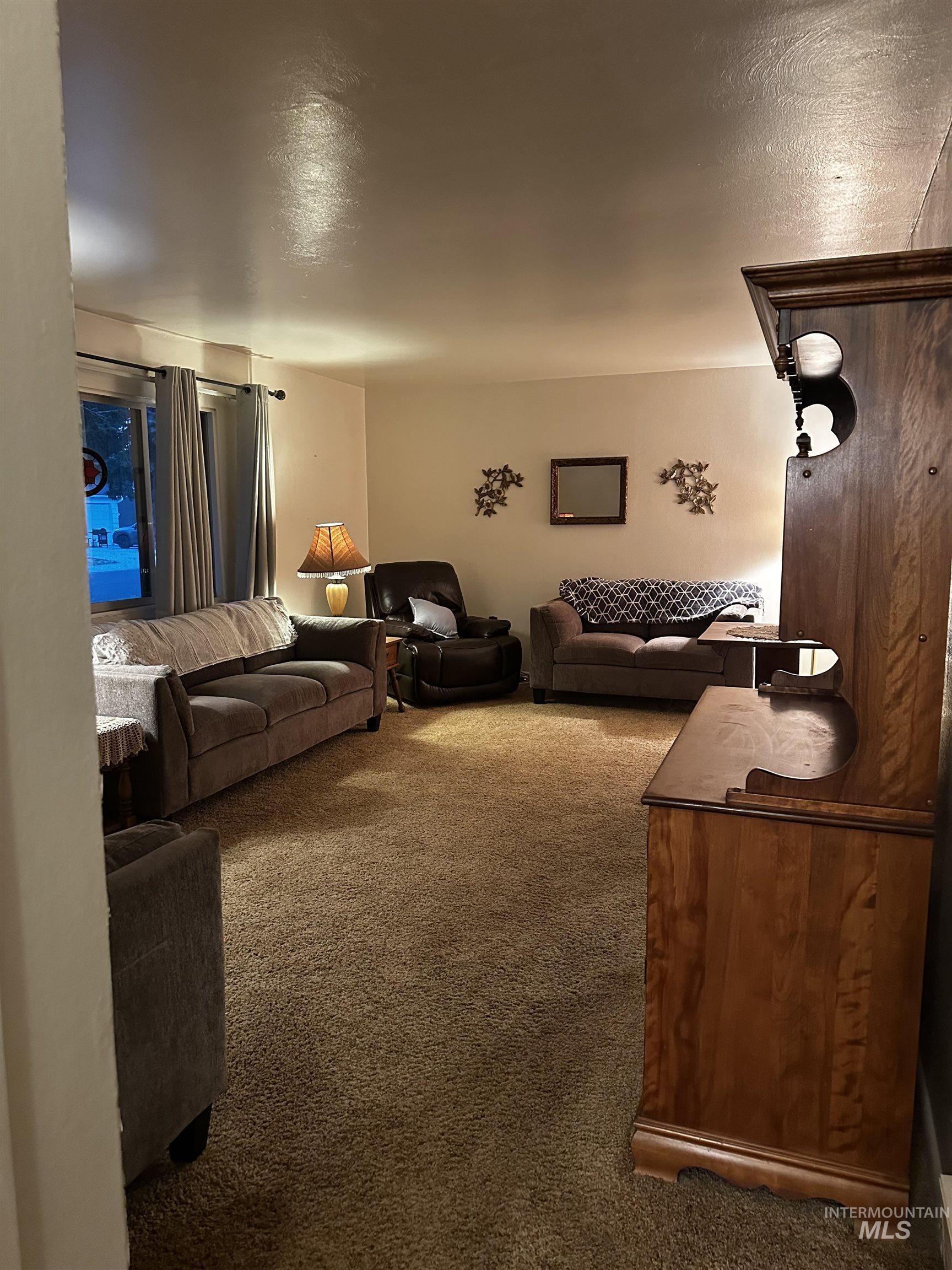 Living area featuring carpet and a textured ceiling