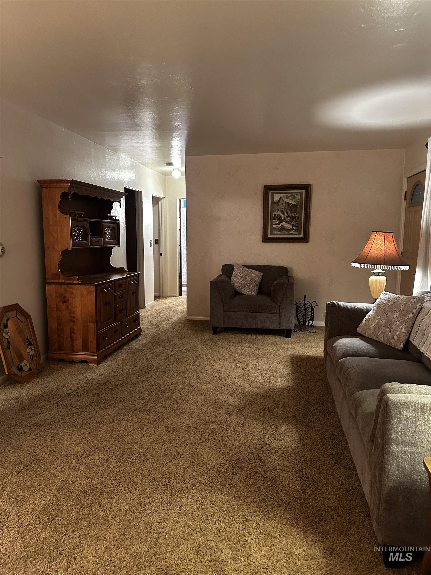 Carpeted living area featuring baseboards
