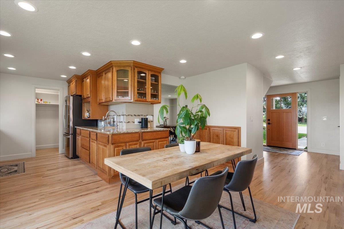 Dining space with recessed lighting, light wood-type flooring, and a textured ceiling
