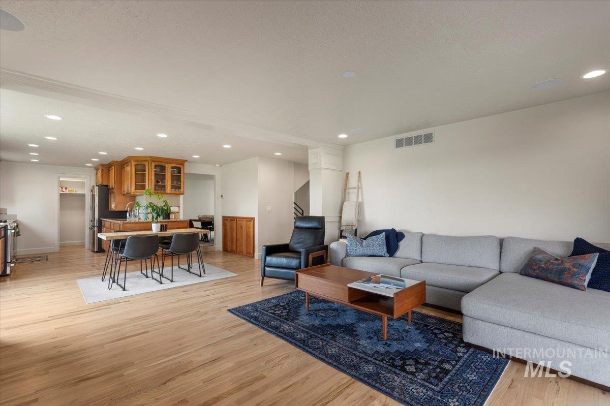 Living room with light wood-type flooring and recessed lighting
