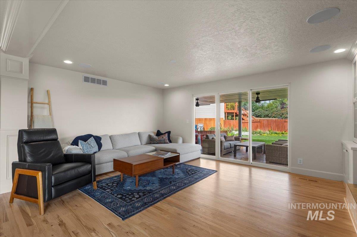 Living area featuring light wood finished floors, recessed lighting, and a textured ceiling
