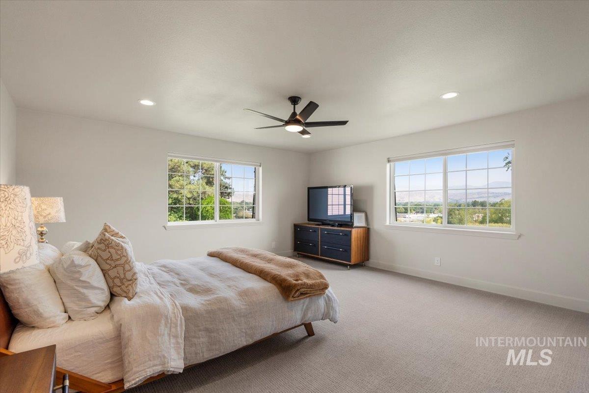 Bedroom with light carpet, a ceiling fan, and recessed lighting
