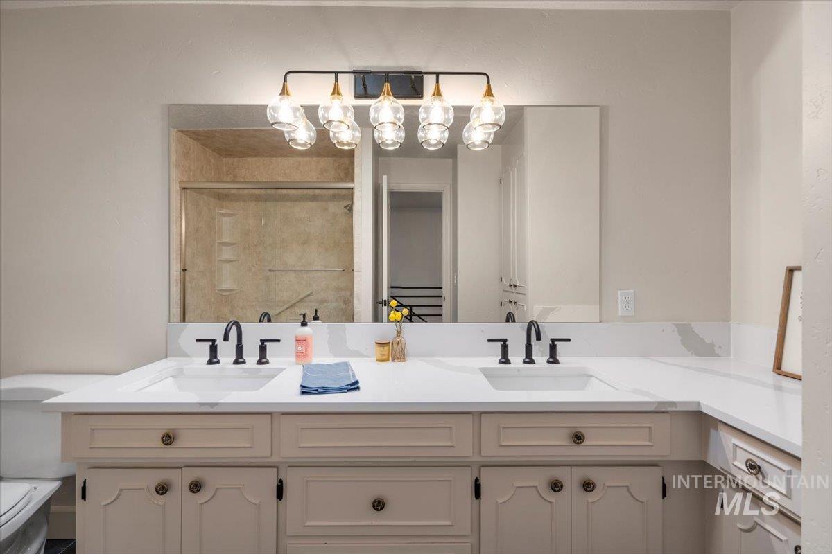 Bathroom featuring a shower stall and double vanity