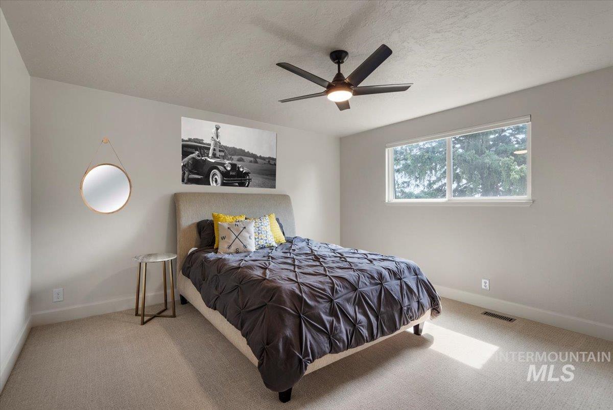 Bedroom featuring carpet floors, a textured ceiling, and a ceiling fan