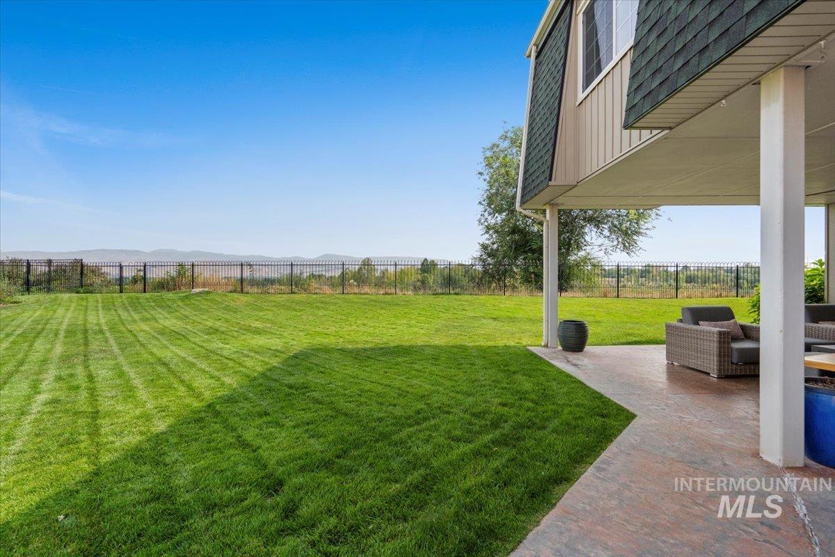 Fenced backyard featuring a patio area and a mountain view