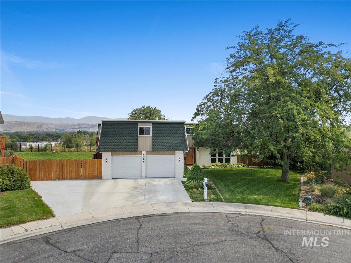 View of front facade featuring mansard roof, roof with shingles, concrete driveway, a mountain view, and a garage