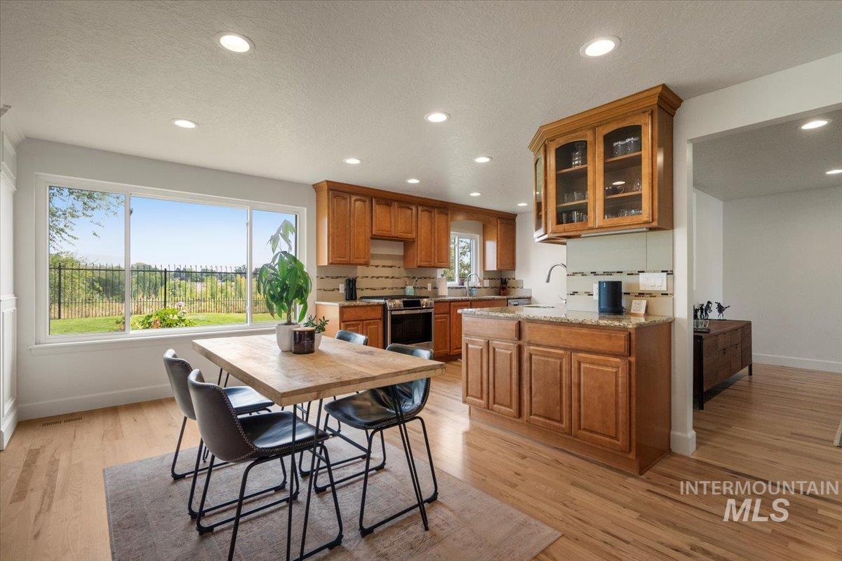 Dining area with recessed lighting, light wood-style flooring, and a textured ceiling