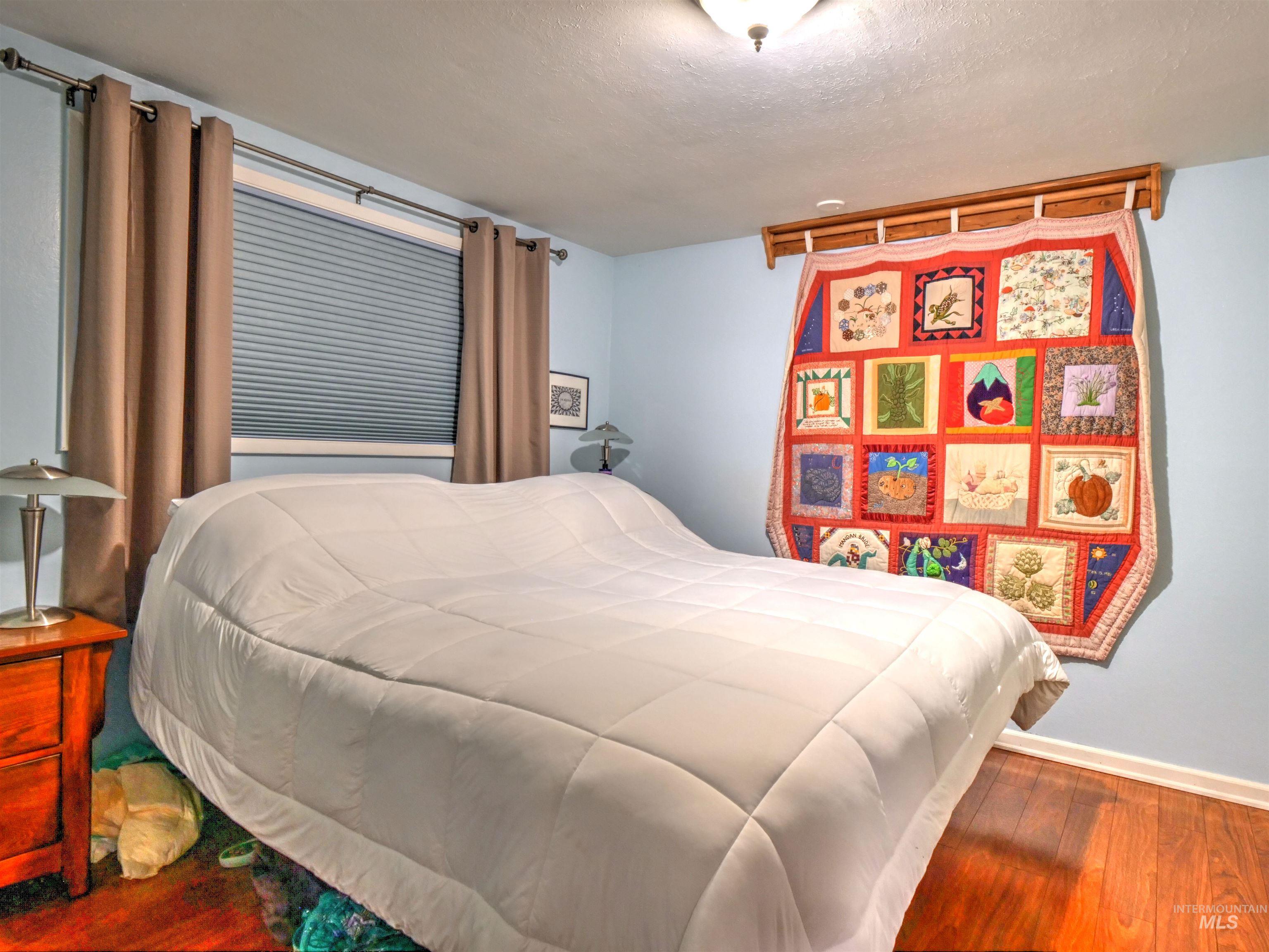 Bedroom featuring wood finished floors and a textured ceiling