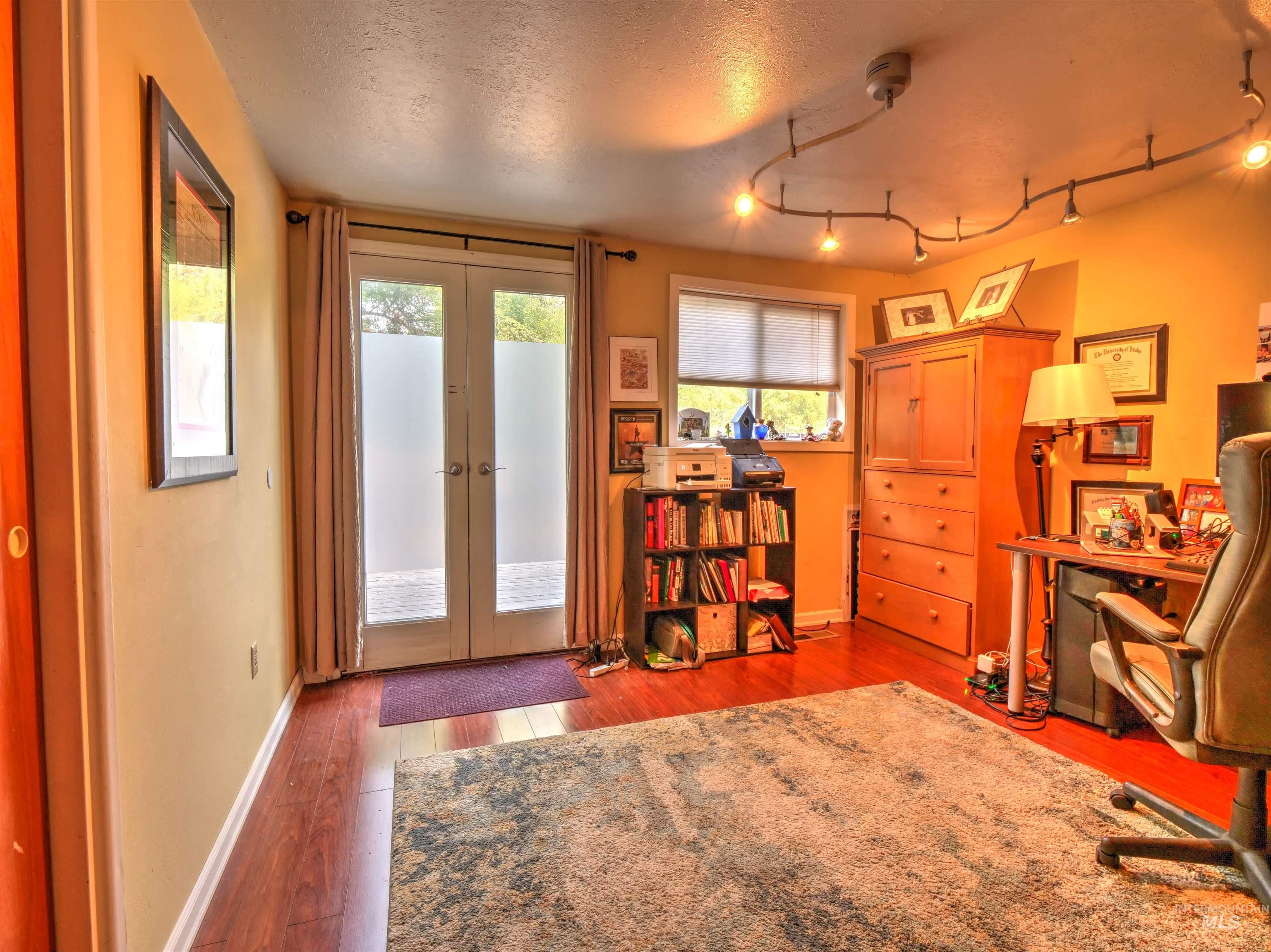 Office featuring french doors, light wood-style flooring, and a textured ceiling