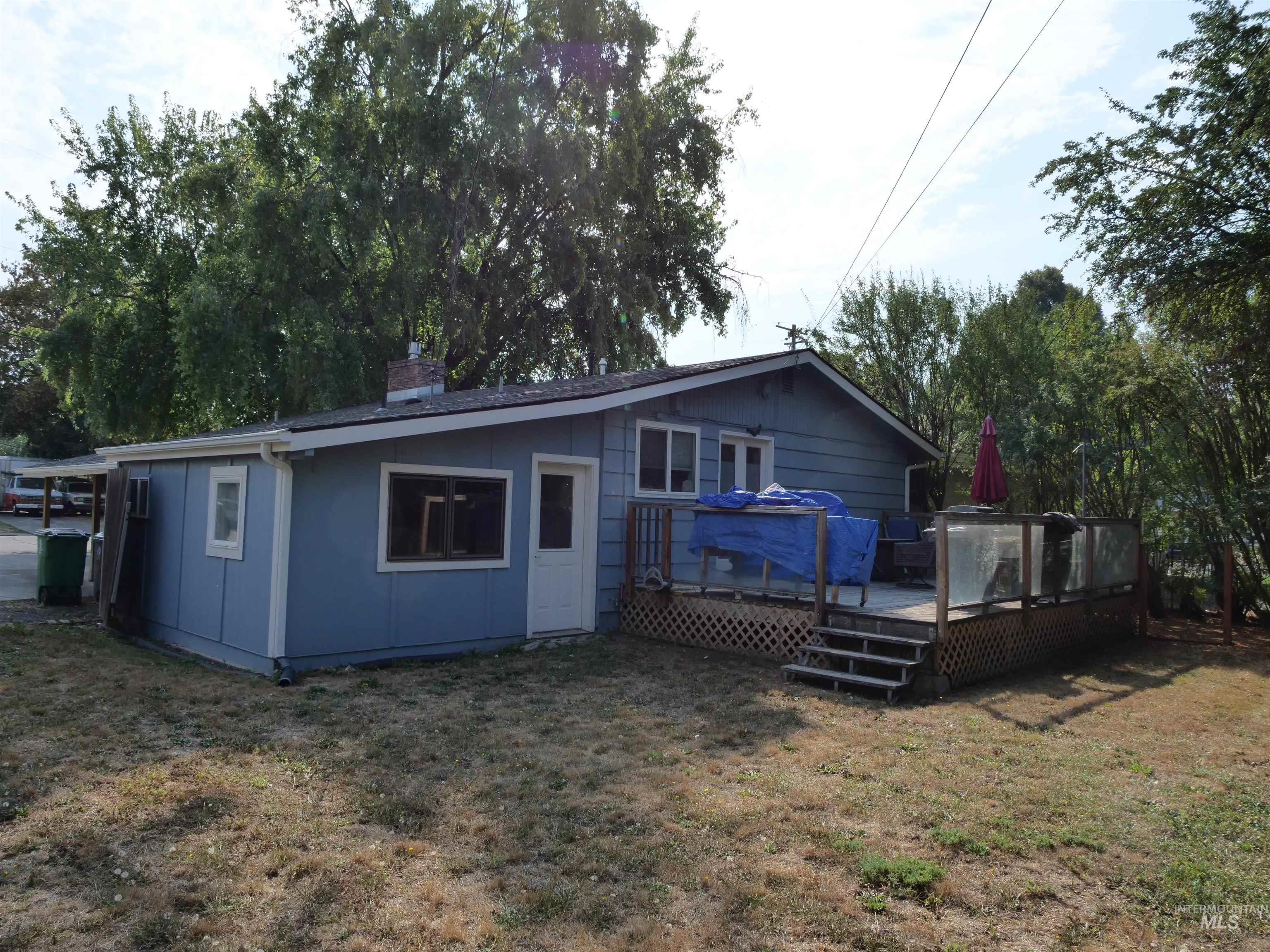 Rear view of property featuring a yard, a wooden deck, and a chimney