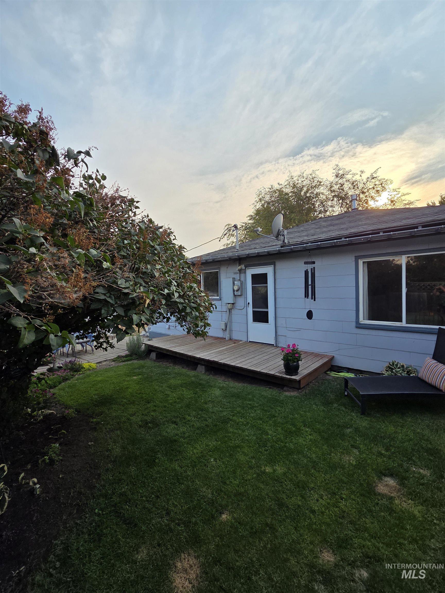 Back of house with a yard and a wooden deck