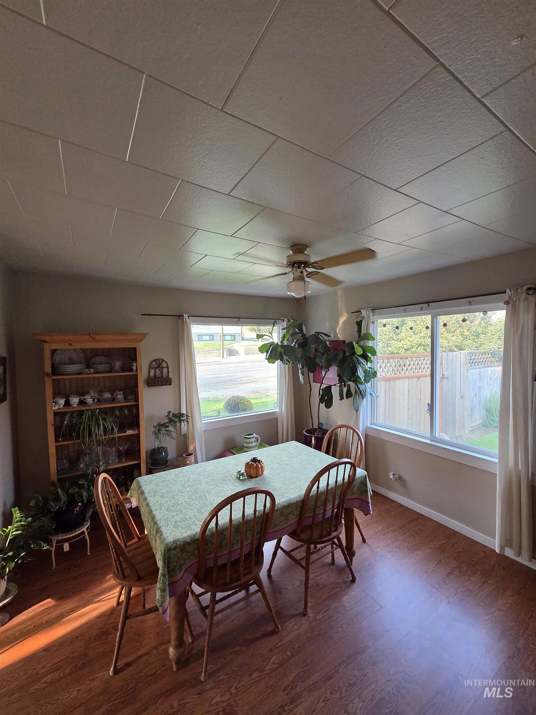Dining area with wood finished floors and ceiling fan