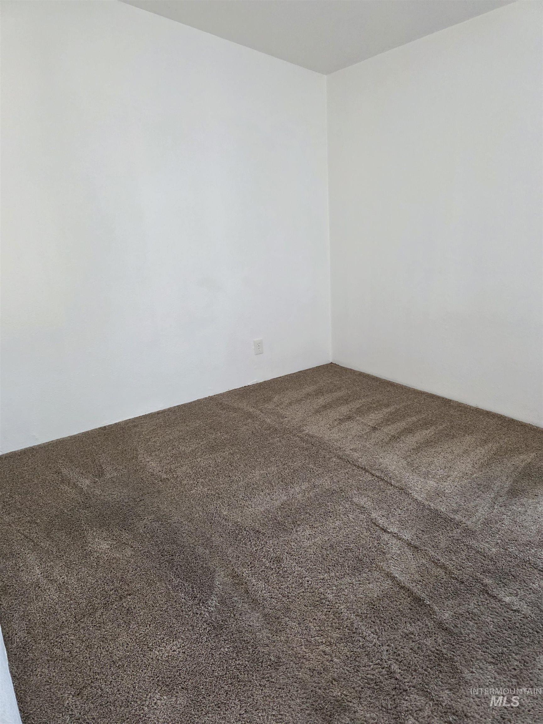 Unfurnished room with dark carpet