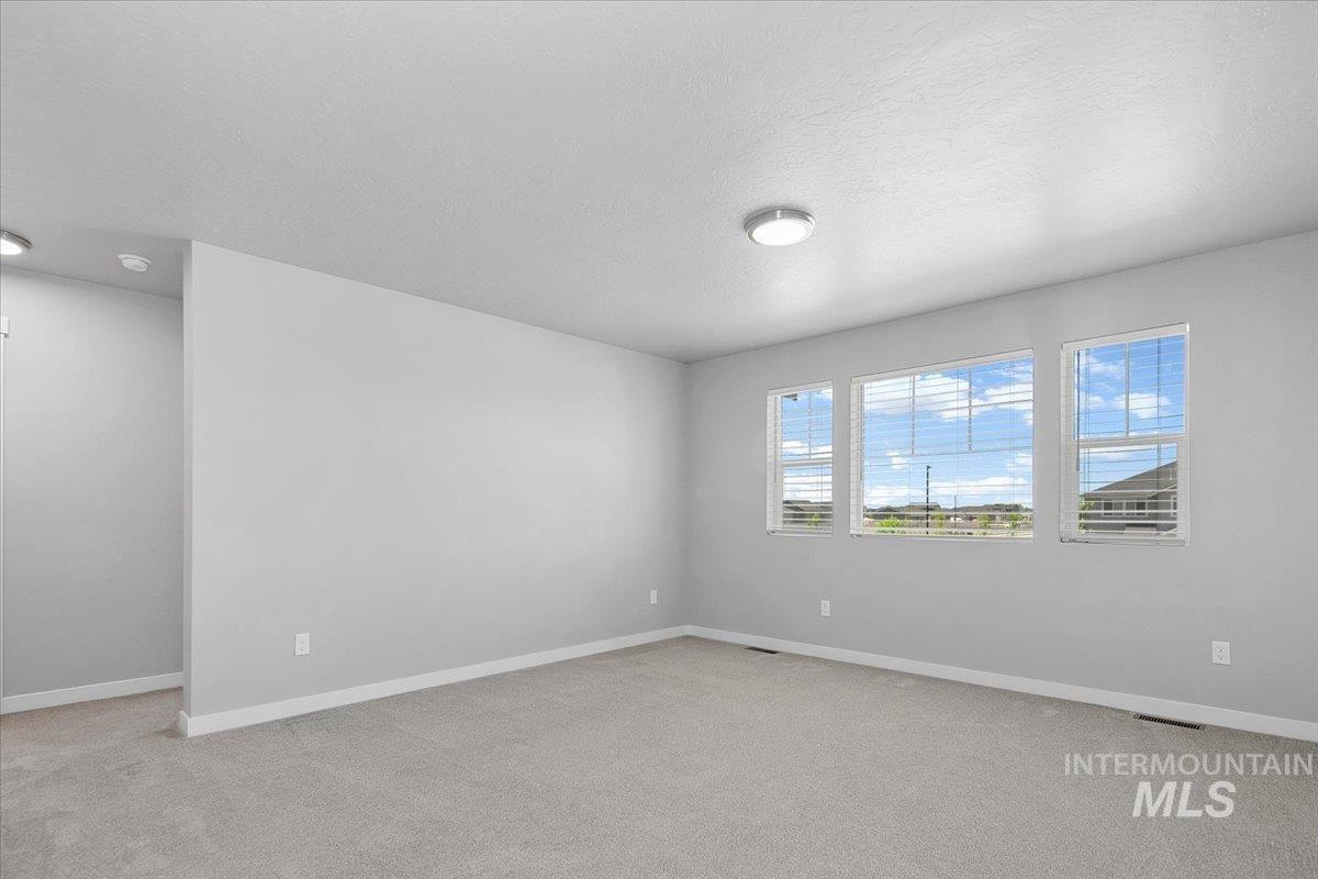 Unfurnished room with light colored carpet and a textured ceiling