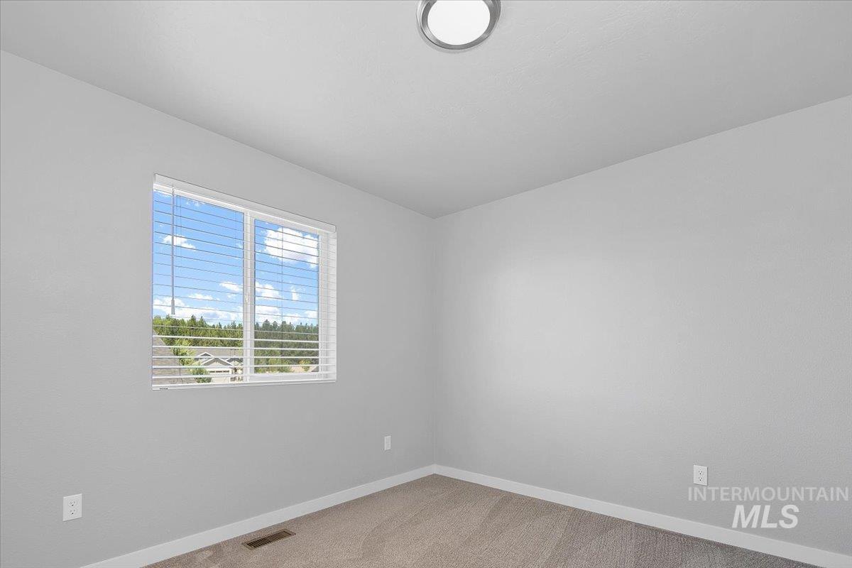 Unfurnished room with light colored carpet and baseboards