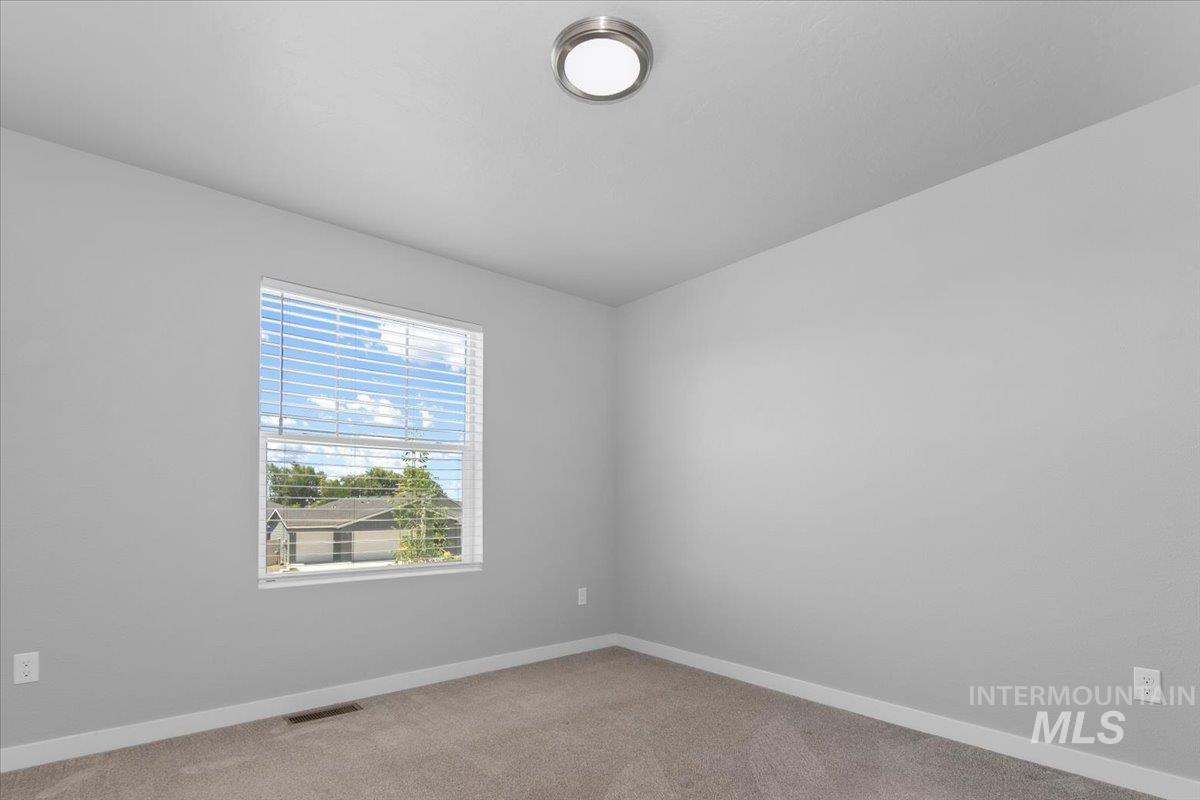 Spare room featuring baseboards and light colored carpet