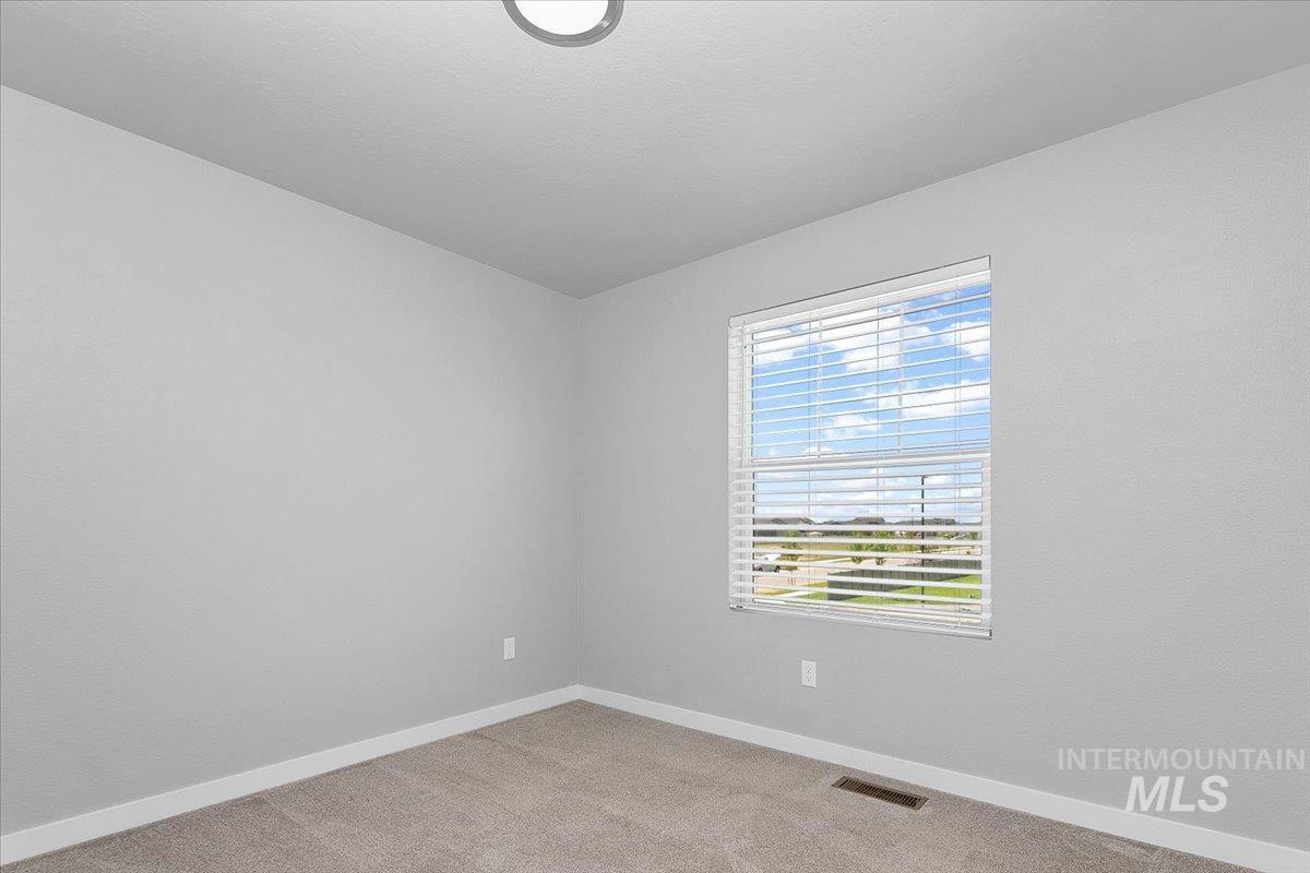 Unfurnished room with baseboards and light colored carpet