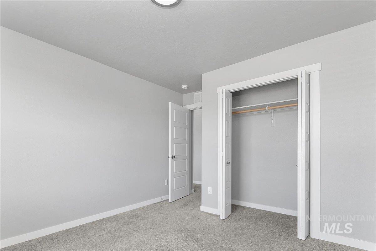 Unfurnished bedroom featuring light colored carpet and a closet