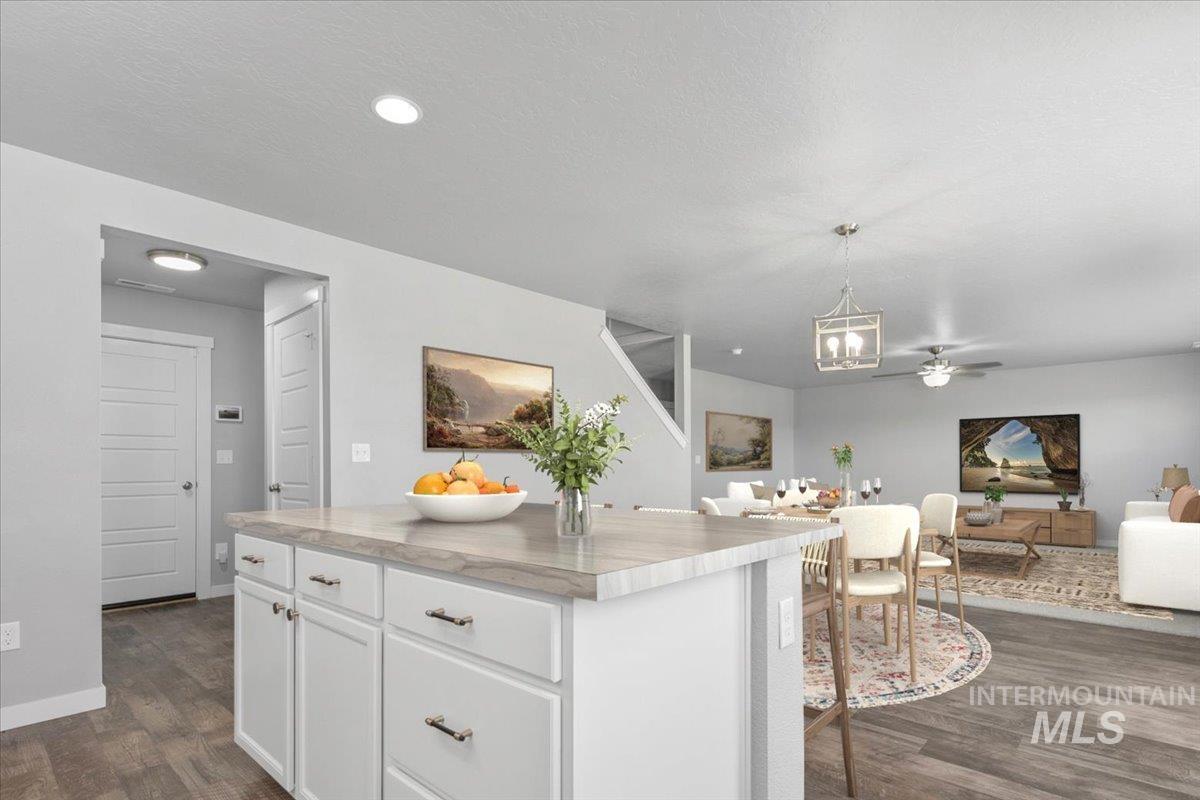 Kitchen featuring white cabinets, decorative light fixtures, dark wood-style flooring, open floor plan, and recessed lighting