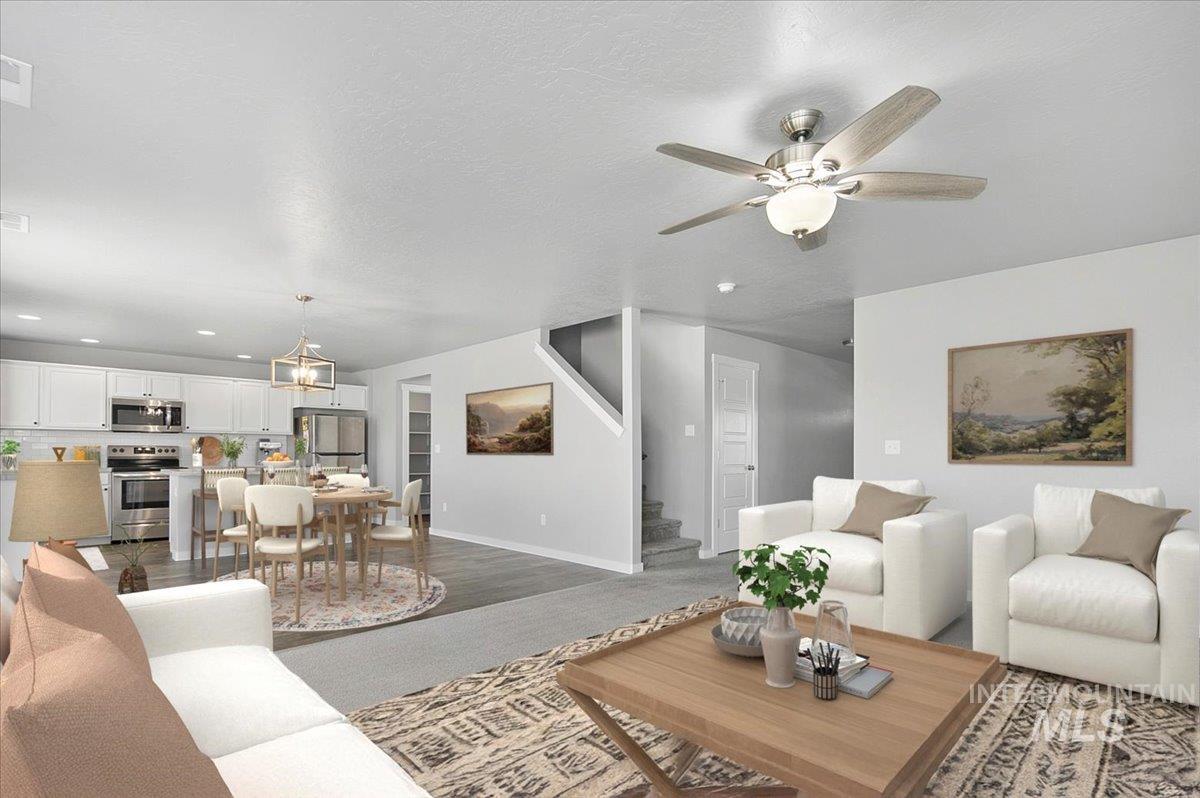 Living area with stairway, ceiling fan, a textured ceiling, wood finished floors, and recessed lighting