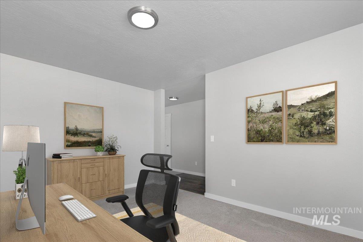 Carpeted office featuring baseboards and a textured ceiling