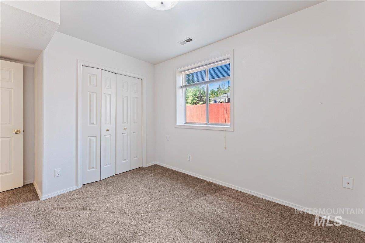 Unfurnished bedroom featuring light carpet and a closet