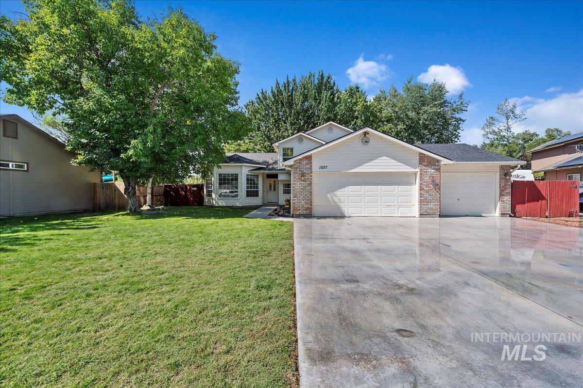 Single story home with brick siding, a garage, and driveway