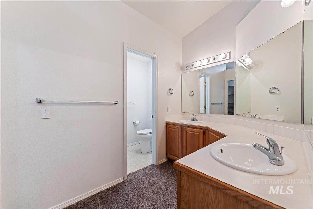 Full bathroom featuring toilet and double vanity