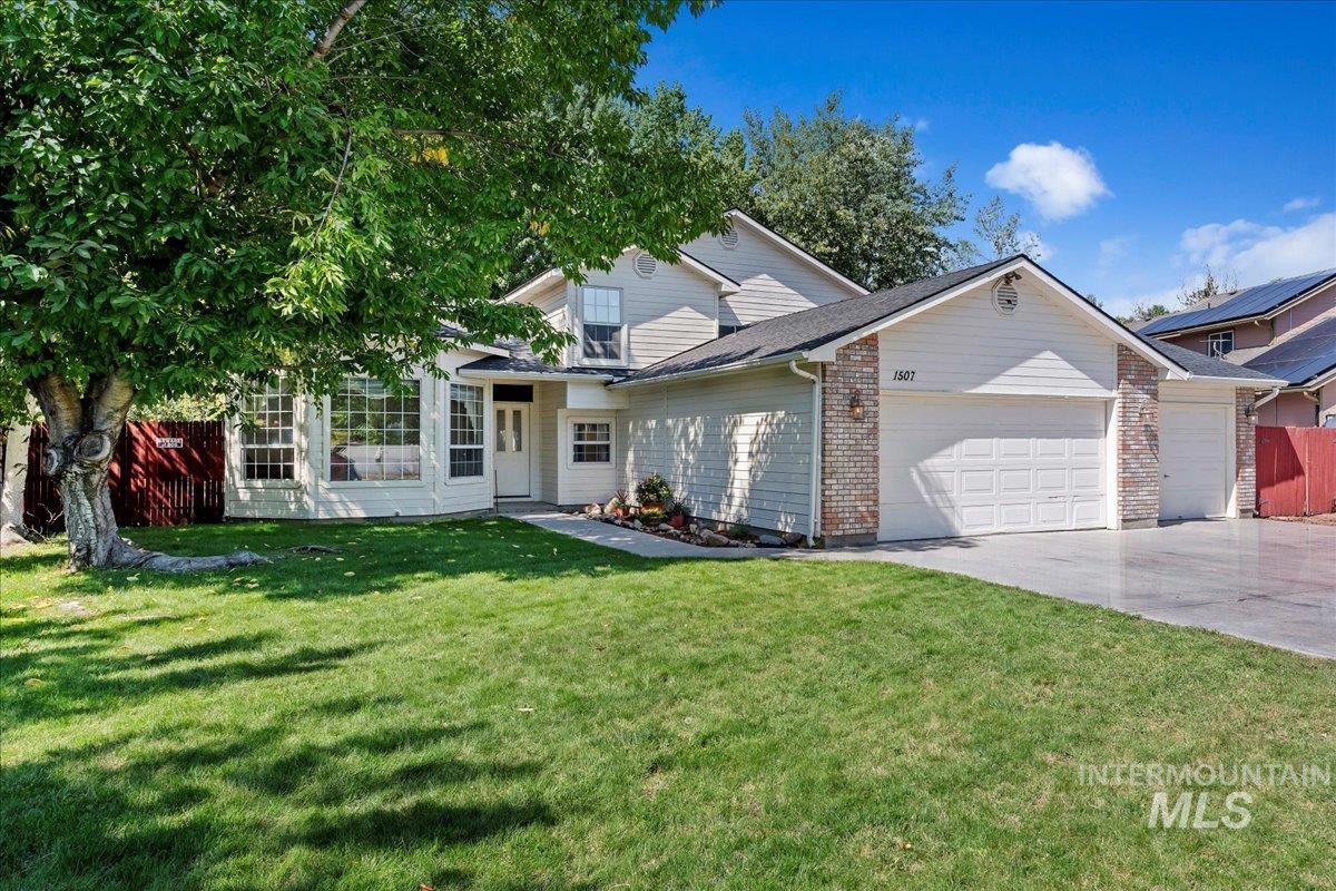 Traditional home with brick siding, an attached garage, and driveway