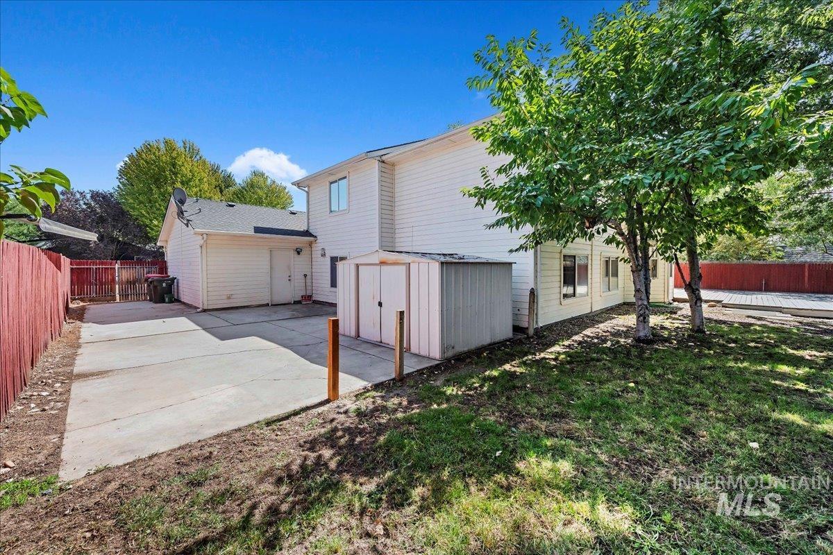 Back of property with a storage unit and a fenced backyard